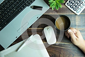 Top view of office stuff graphic design hand holding a coffee cu