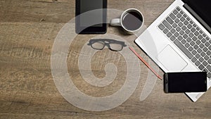 Top view office table desk. Workspace with blank, office supplies,Laptop, pencil, and coffee cup on wood background.