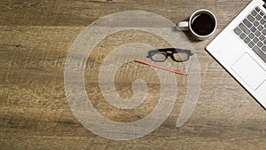 Top view office table desk. Workspace with blank, office supplies,Laptop, pencil, and coffee cup on wood background.