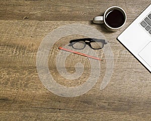 Top view office table desk. Workspace with blank, office supplies,Laptop, pencil, and coffee cup on wood background.