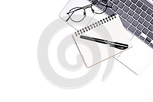 Top view office white table desk. Workspace with computer laptop, keyboard, office supplies, and  eyeglass on white background