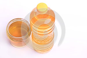 Top view of oil in glass bottle and yellow cap on plastic bottle isolated on white background, selective focus. negative space