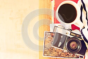 Top view of old camera, cup of coffe and stack of photos. filtered image. travel or vacation concept
