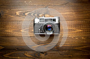 Top view of old camera on wooden background