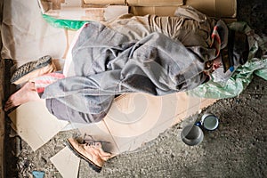 Top view of old homeless man wearing sweater and blanket sleeping on cardboard seeking help because hungry and food beggar from