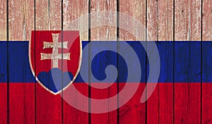 Pohľad zhora na starú maľovanú zástavu Slovenska na tmavom drevenom plote, stena. patriot a cestovateľský koncept. žiadny stožiar. Pozadie vlajky.