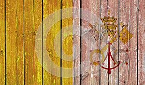 Top view of Old Painted Flag of Vatican City Holy See on Dark Wooden Fence, wall. patriot and travel concept. no flagpole. Flag