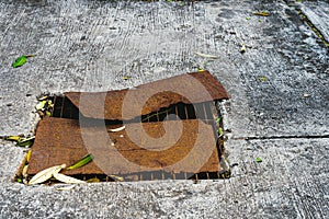 Top view of old rusted metal plate was used to cover the broken steel grating of road drain cover. Rusted steel plate cover on