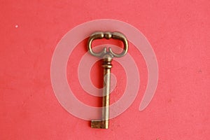 Top view of an old rusty key isolated on a red background