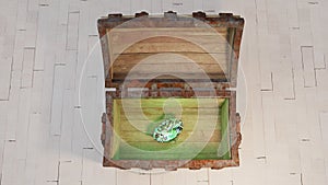 Top view of an old wood with rusty metal Chest opened with a very big green diamond inside