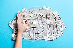 Top view of one hundred dollar bills in one hand and showing okay gesture with another hand on colorful background. Prosperity and