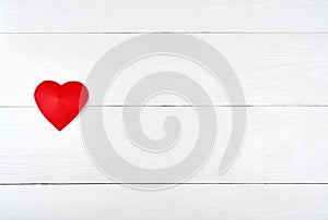 Top view of one red paper heart on white wooden background, copy space for text. Greeting card mockup for Saint Valentines Day,