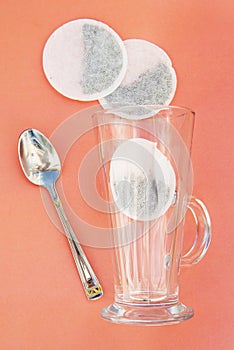 Top view of one tea bag and empty glass cup isolated on pink.