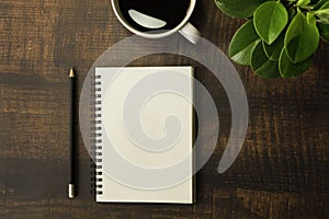 Top view of open school notebooks with blank pages, Pencil, Plant and Coffee cup on wooden table background. Business, office or e