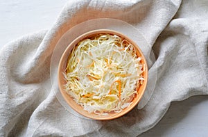 Top view of bowl of sauerkraut with cabbage on towel