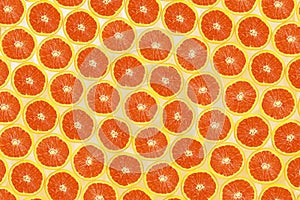 Top view of orange fruit half slices on orange pastel background for background or wallpaper