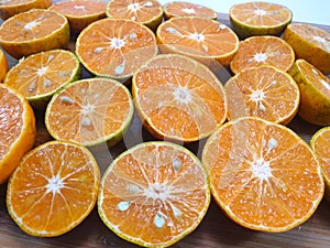 Top view of orange fruit slice on cutting board as a background ready to eat or making drinks