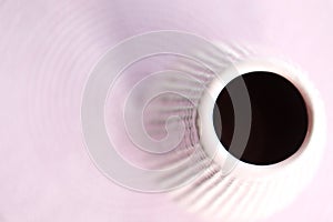 Top view of orange gerbera flower in blue bottle throwing a shadow on a white background