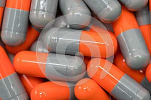 Top view of orange, grey, capsule pills