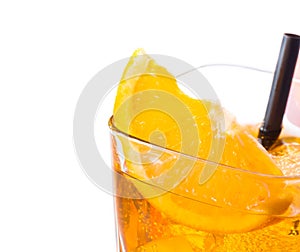 Top of view of orange slice on top of the yellow cocktail with ice cubes and straw on white background