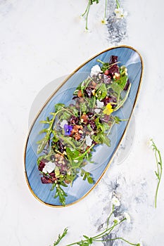 top view organic baby greens salad with beetroot, goat cheese, pistachios and citrus dressing