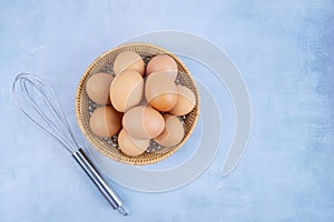 Top view of organic chicken eggs in basket on wooden background