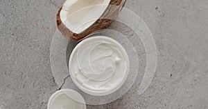 Top view on organic cream with coconut oil in jar on tile background