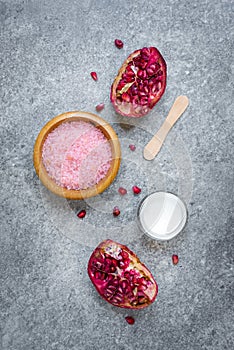 Top view of organic pomegranate fruit cosmetics over grey stone background