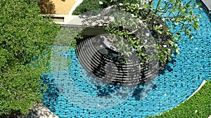 Top view outdoor pool pond and fountain amid tropical garden