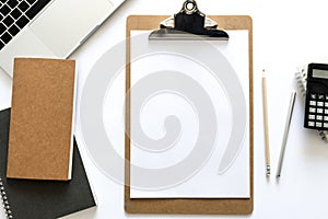 Top view over the working desk with notebook, pencil, paper, laptop and calculator. Copy space for text. Flat lay of a workplace o