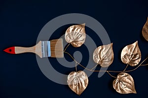paint brush with golden ive leaves on a black background photo