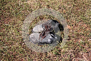 Top view of a pair of old black dirty smelly boots stained with white paint.