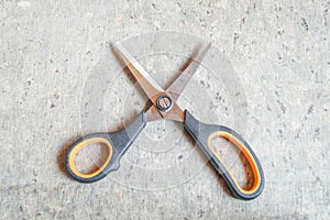 Top view of a pair of scissors kept on a textured brown table. Space for text. Copy space provided