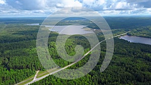 Top view of panorama of forests, lakes and roads. Clip. Panorama of road in forest area with lakes on background of