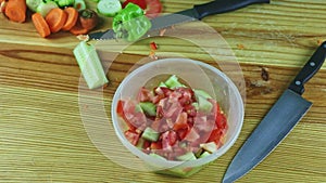 Top view panorama from plastic bowl with vegetable salad served with big knife