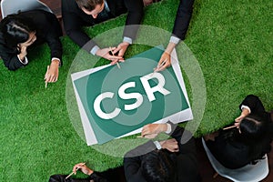Top view panoramic CSR symbol on grass table with business people. Quaint