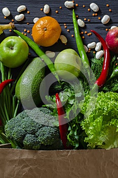 Top view paper bag of different fresh health food on white wooden background