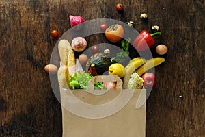 Top view paper bag different health food wooden background