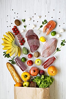 Top view, paper bag of various health food. Healthy eating. White wooden background. From above,