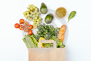 Top view paper grocery shopping bag with healthy food fresh vegetables