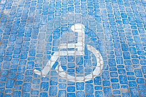 Top view on parking sign for disable people. Disabled parking space and wheelchair symbols on pavement