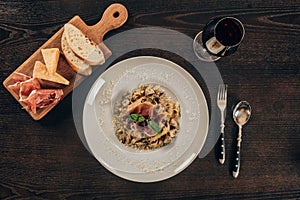 top view of pasta with meat and glass of red wine