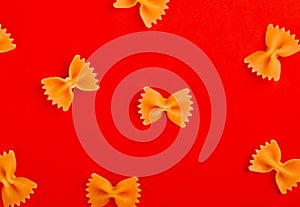 top view of pattern of farfalle pasta on red background