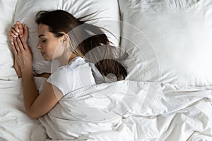 Top view peaceful young woman sleeping on side in bed