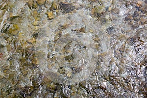 Top view of pebble stones in fast-moving stream