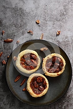 top view pecan tarts on a grey plate