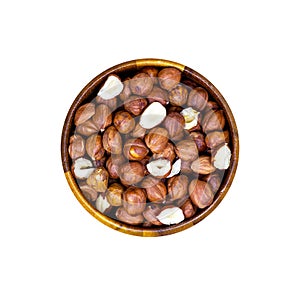 Top view of peeled brown hazelnuts in round wooden bowl isolated on white background.