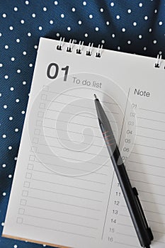 Top view of Pen on Blank To Do LIst on Blue Polka Dot Background