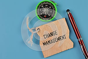 Top view of pen, compass and wooden board written with CHANGE MANAGEMENT