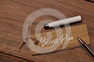Top view of pen and memo note written with SUCCESS PLAN